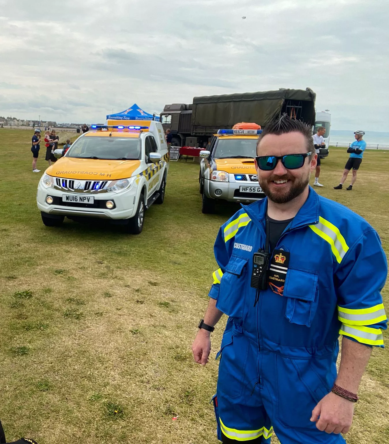 Kev Paterson stood in front of two Coastguard Rescue Vehicles