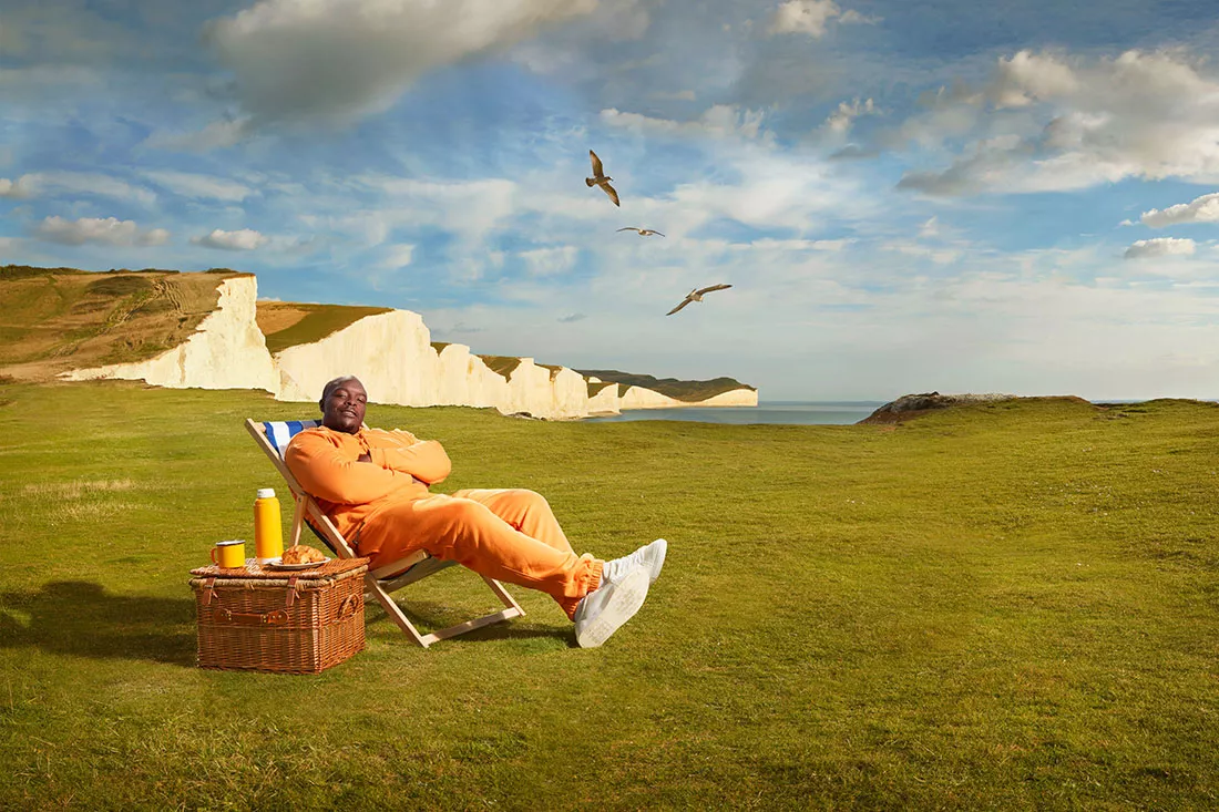 Adebayo sits in a deck chair admiring the cliff view